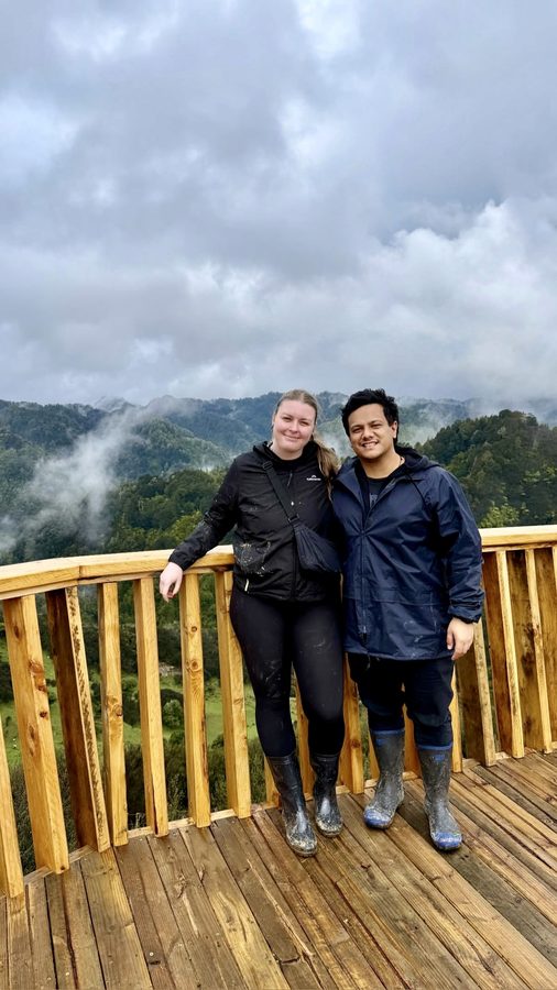 Zoe and Tyler on a deck overlooking misty hills