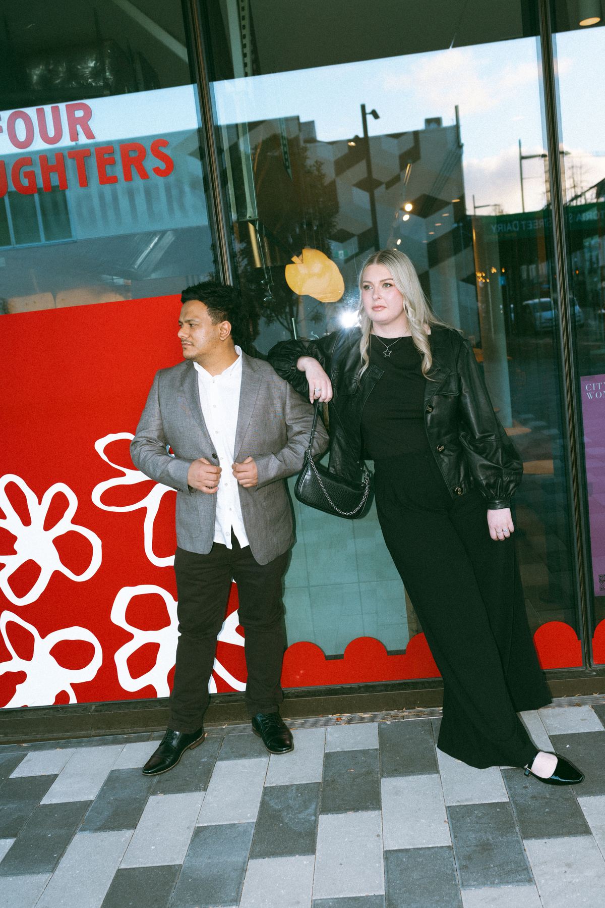 Zoe and Tyler posing outside a bright red shopfront
