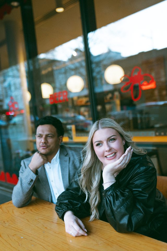 Zoe and Tyler sitting at a cafe table by the window