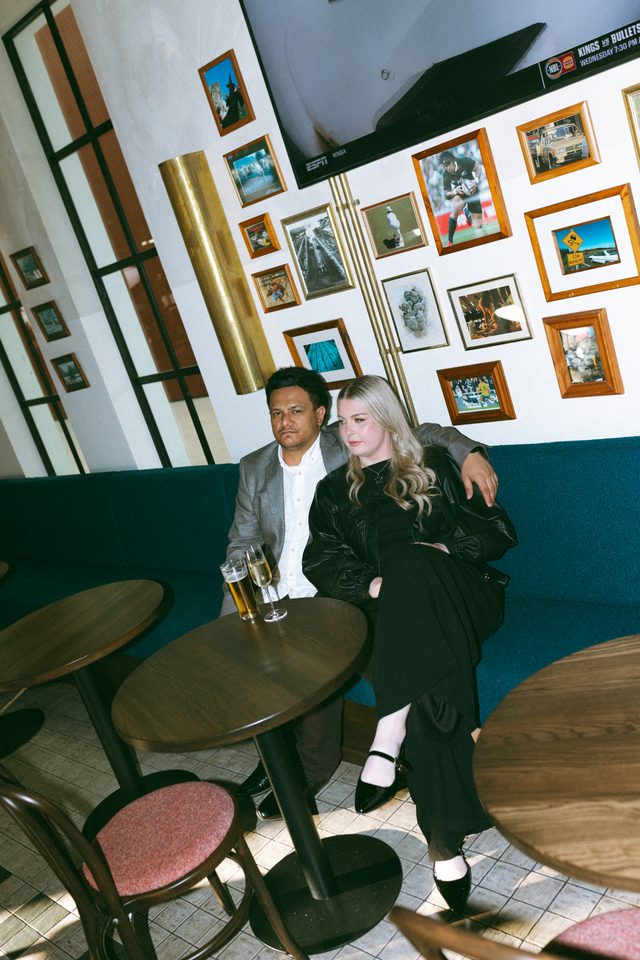Zoe and Tyler sharing a drink in a bar booth
